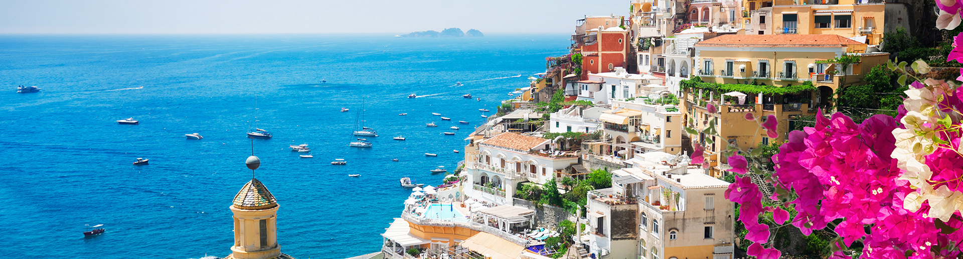 Stunning view of the Amalfi Coast sailing itinerary with Positano, Italy – A yacht cruising along the vibrant coastline, framed by dramatic cliffs and colorful Mediterranean buildings, showcasing the natural beauty and charm of this iconic destination.